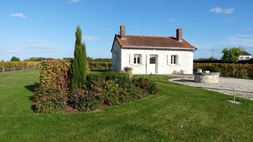 a small white house with a garden in front of it at l'Ecrin au coeur des vignes in Saint-Georges-sur-Cher