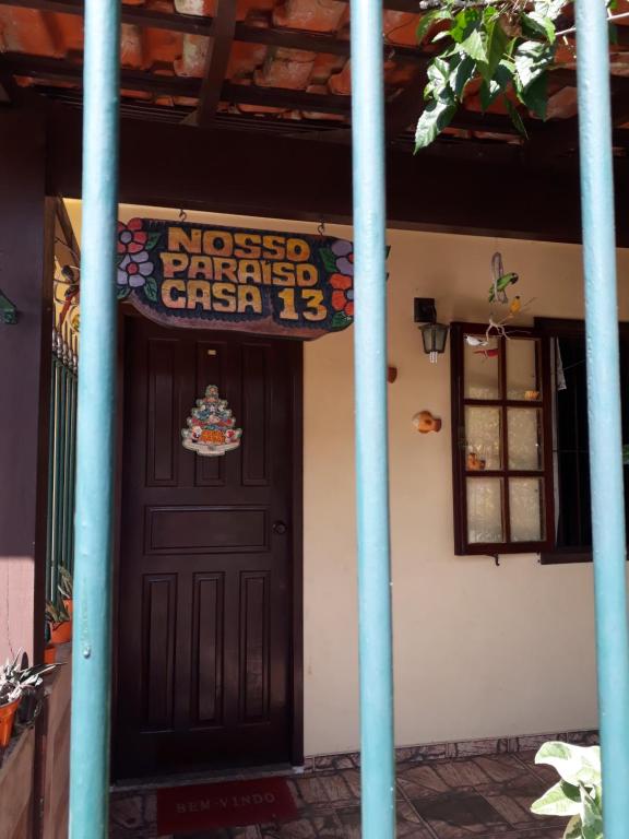 une porte menant à une maison avec un panneau sur celle-ci dans l'établissement Casa Completa na Praia, à Saquarema