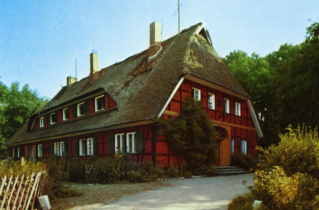 uma grande casa vermelha com um telhado de gambrel em Pension Forstgut Einem em Einem