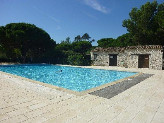 a large blue swimming pool next to a building at GASSPON - Golfe de St-Tropez - Mazet dans domaine privé avec piscine et tennis in Cogolin