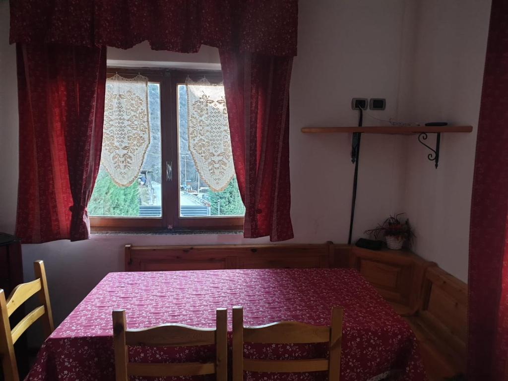 a dining room with a table and a window at Il Dehors in Champdepraz