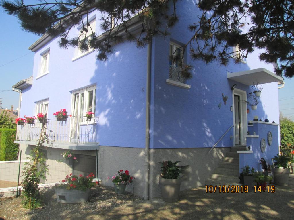 a blue house with flowers on the balcony at Gîte du Coq in Lingolsheim