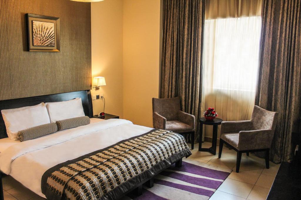 a hotel room with a bed and a chair at Dunes Hotel Apartment Oud Metha, Bur Dubai in Dubai