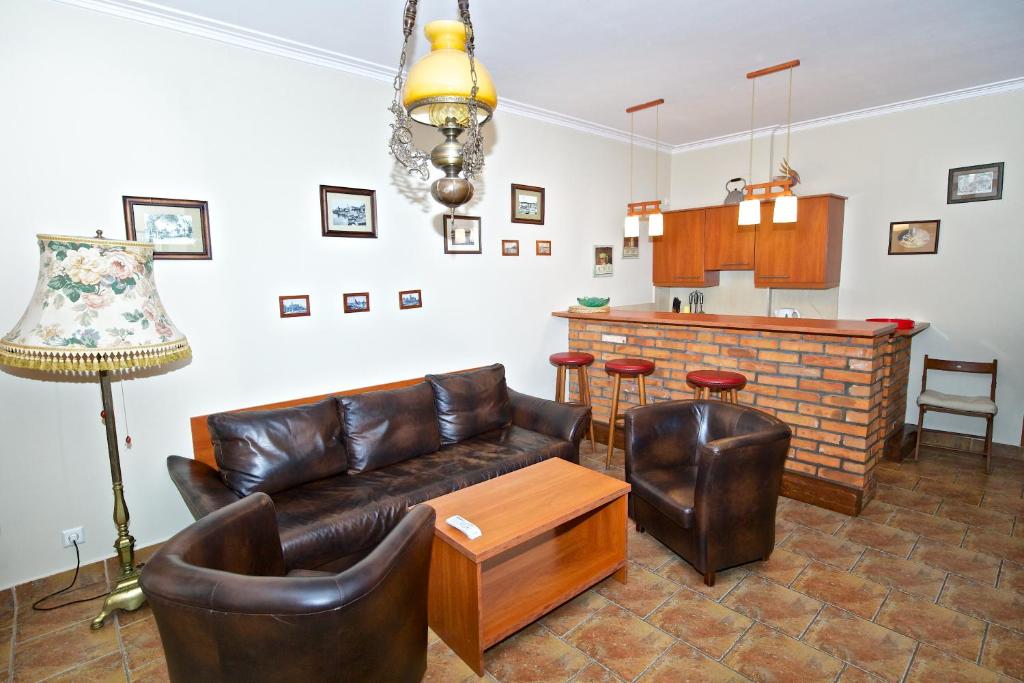 sala de estar con sofá de cuero y bar en Apartments ADMIRAL NELSON, en Hel