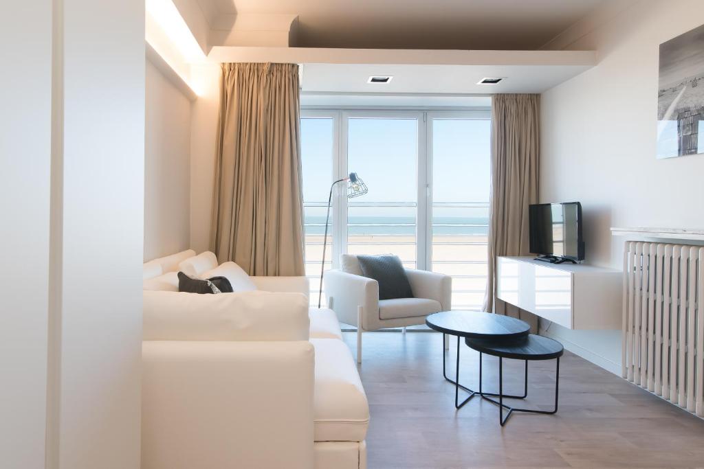 a living room with a white couch and a table at Ter Duinen in Ostend