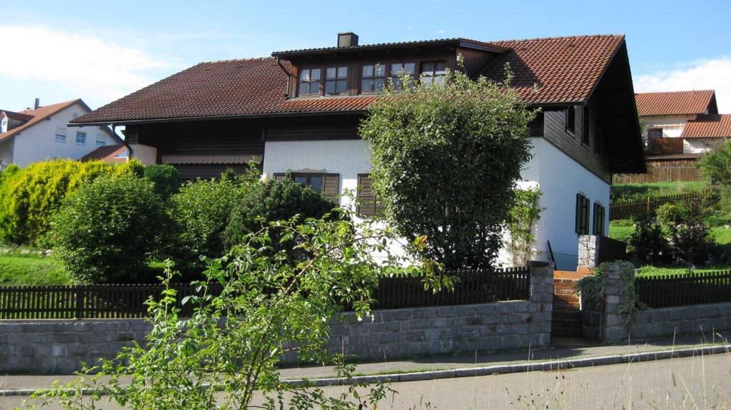 a white house with a fence in front of it at Ferienwohnung Bücherl in Waldmünchen