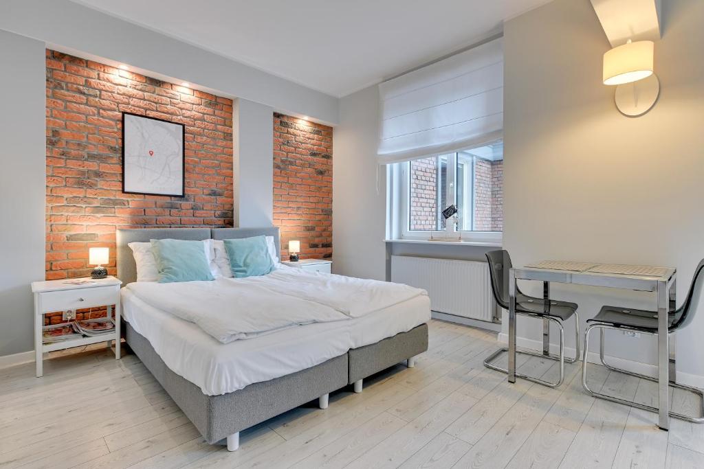 a bedroom with a bed and a desk in it at Comfort Apartments Old Town in Gdańsk