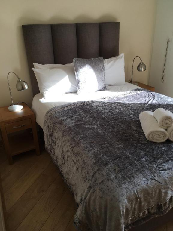 a bedroom with a large bed with two towels on it at Blue Sky Apartments@Guildford Town Centre in Guildford