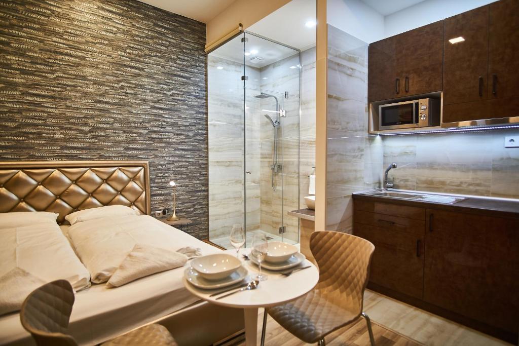 um quarto com uma cama, um chuveiro e uma mesa em K51 Apartman | Budapest em Budapeste