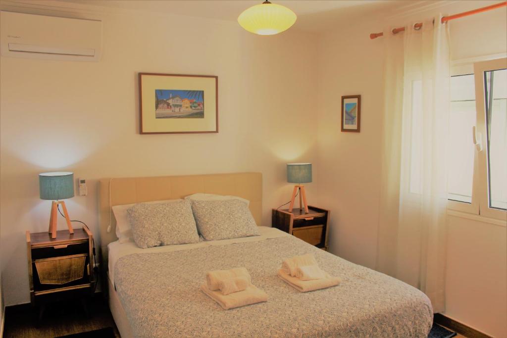 a bedroom with a bed with two towels on it at Apartamento em frente ao Mar in Costa Nova