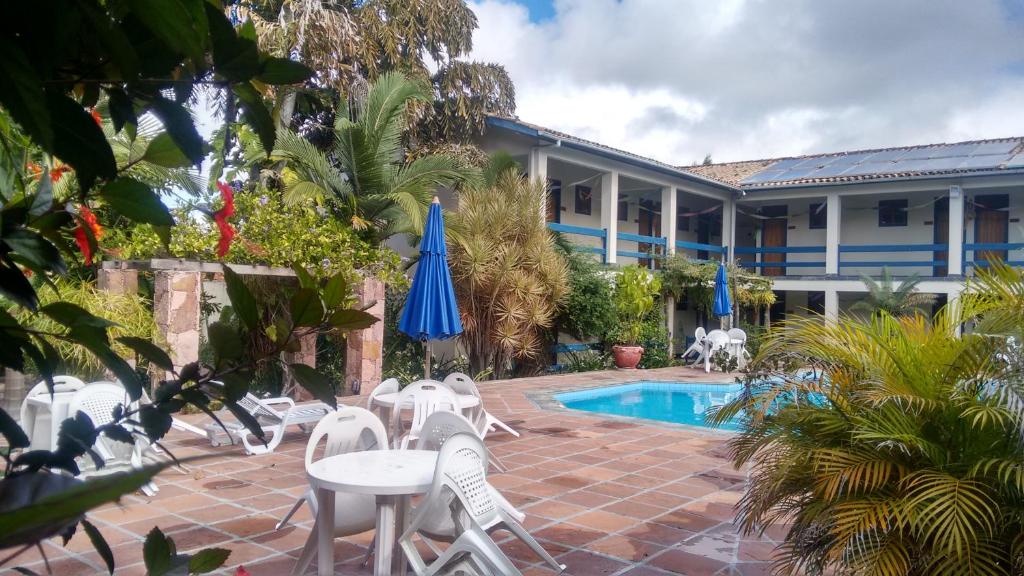 een resort met een zwembad en stoelen en een gebouw bij Pousada Mucugê in Mucugê