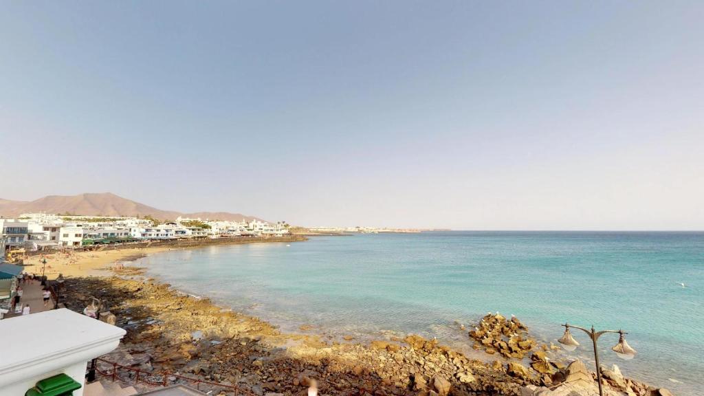 a view of a beach with buildings and the ocean at Blancazul Casa Domingo in Playa Blanca