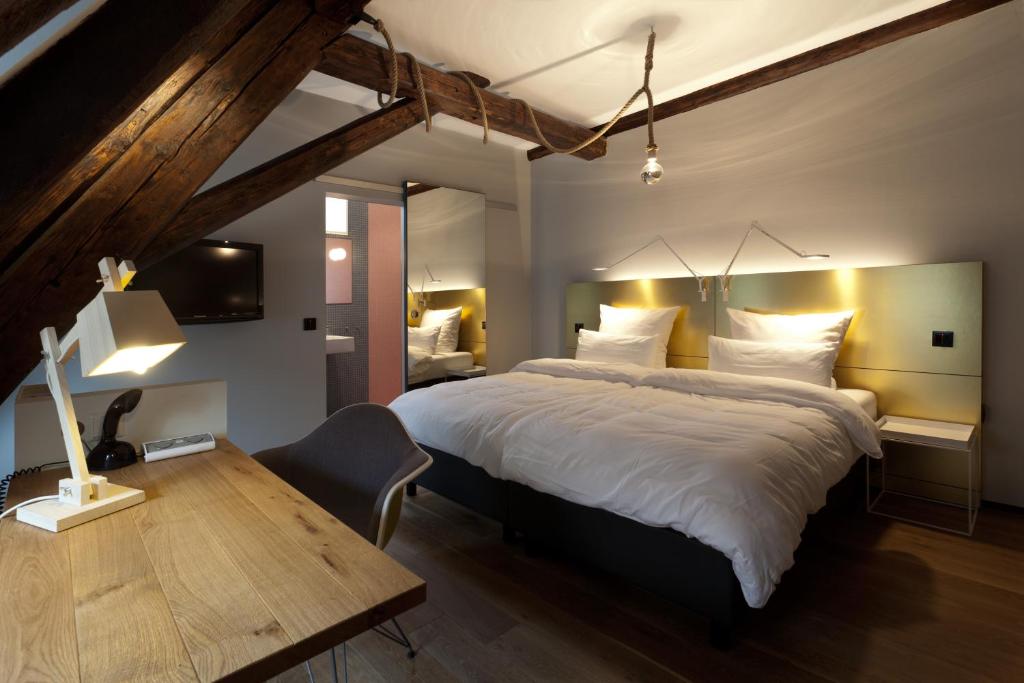 a bedroom with a large bed and a wooden desk at Hotel Scholl in Schwäbisch Hall