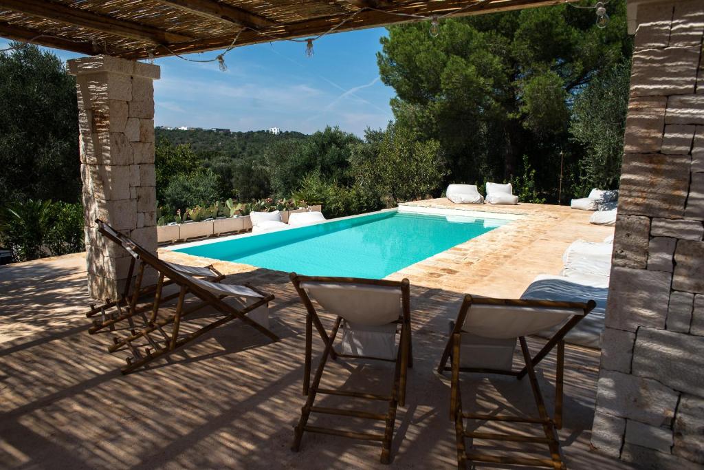 patio con sedie e piscina di Masseria Oreglia a Ceglie Messapica