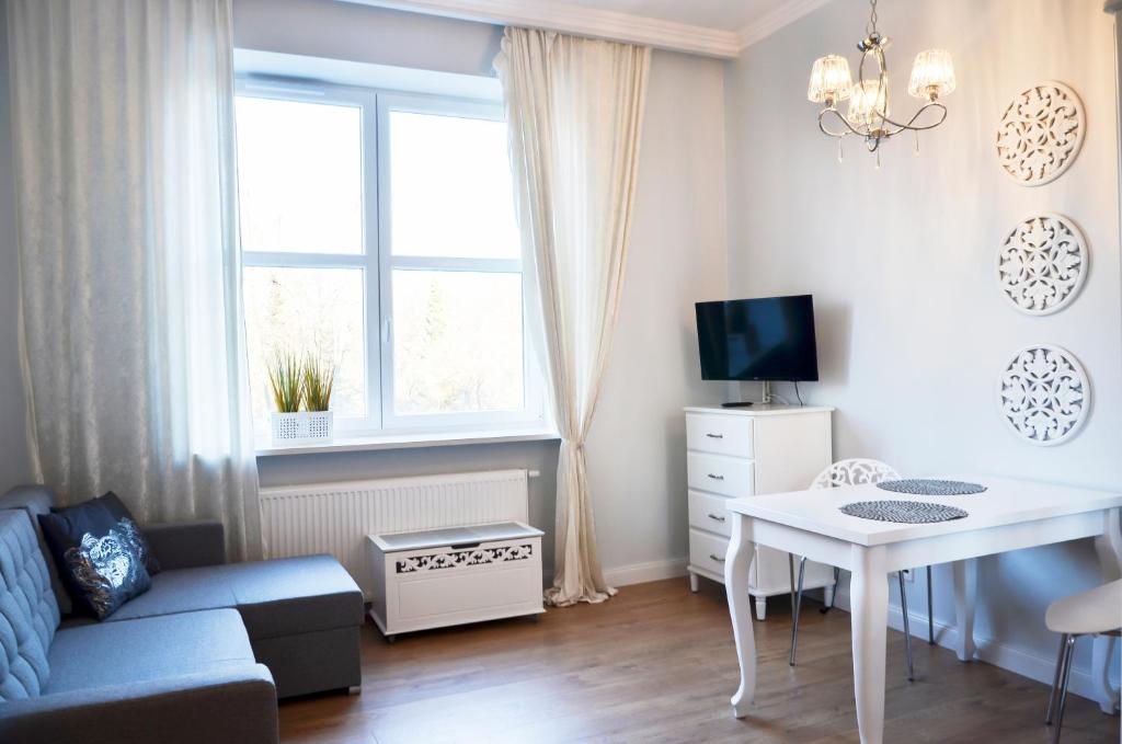 uma pequena sala de estar com um sofá e uma mesa em Gagarina 33 - studio by Homeprime em Varsóvia