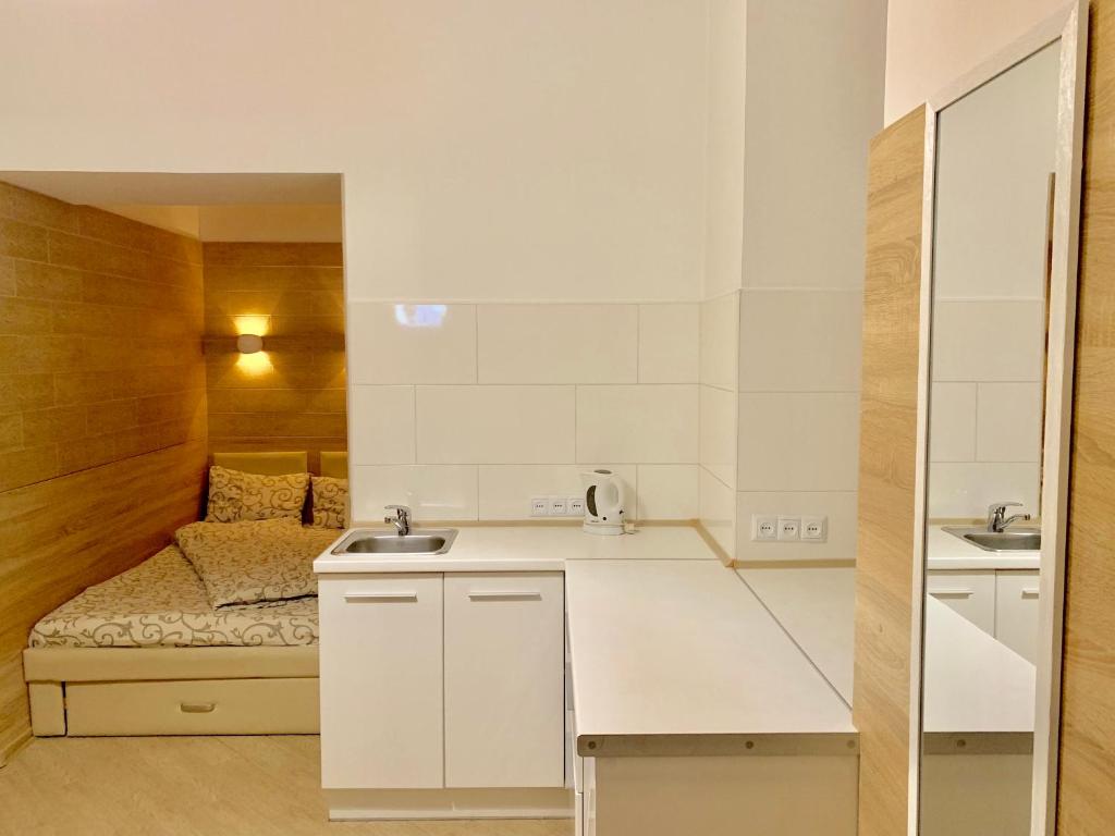 una piccola cucina bianca con un letto sullo sfondo di Невелика Smart квартира в центрі для пари a Lviv