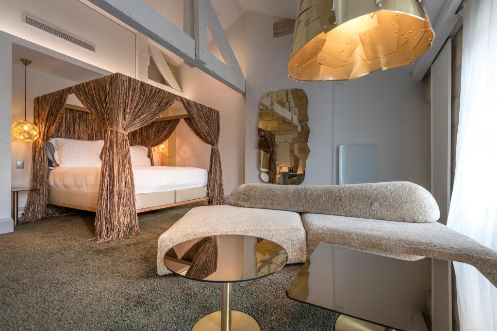 1 dormitorio con 1 cama con dosel de árbol en Yndo Hôtel en Burdeos