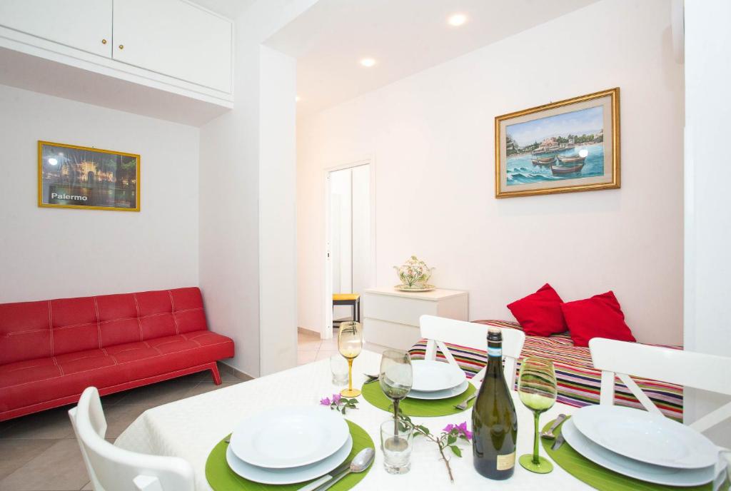 a living room with a table and a red couch at Casa da Silvia in Palermo