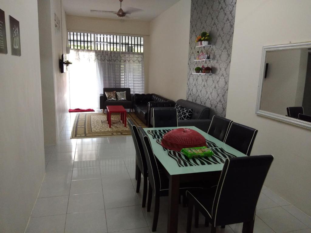 Zah’ra Homestay في كوالا ليبيس: غرفة معيشة مع طاولة وكراسي