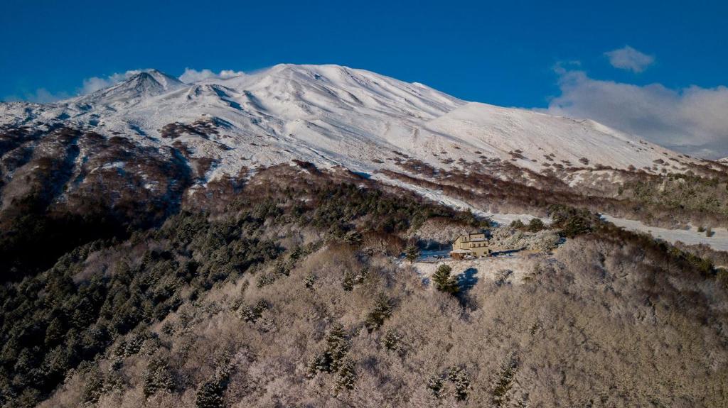 a snow covered mountain with a house on top of it at Rifugio Alpino Salvatore Citelli in Fornazzo