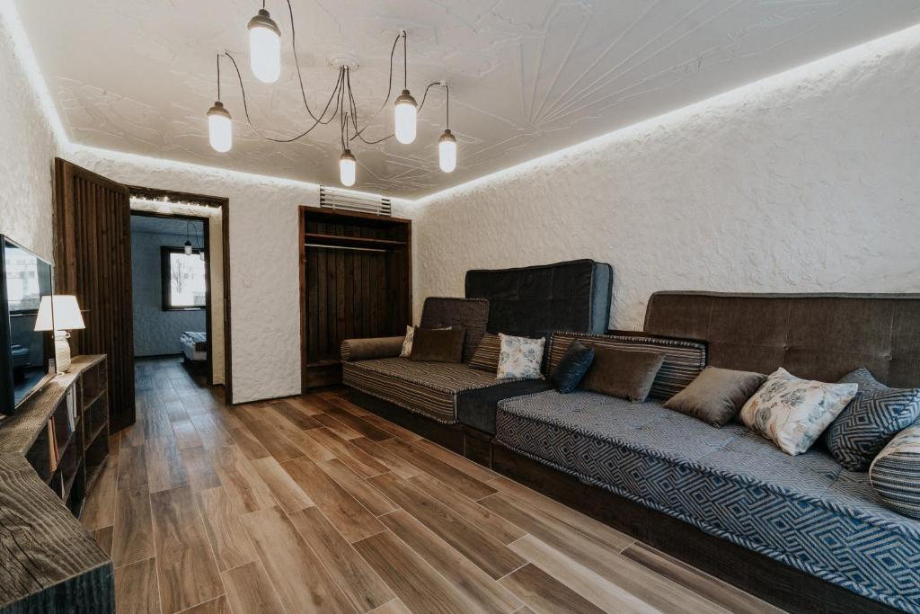 sala de estar con sofá y TV en Pastorale Apartman, en Zalaszentgrót