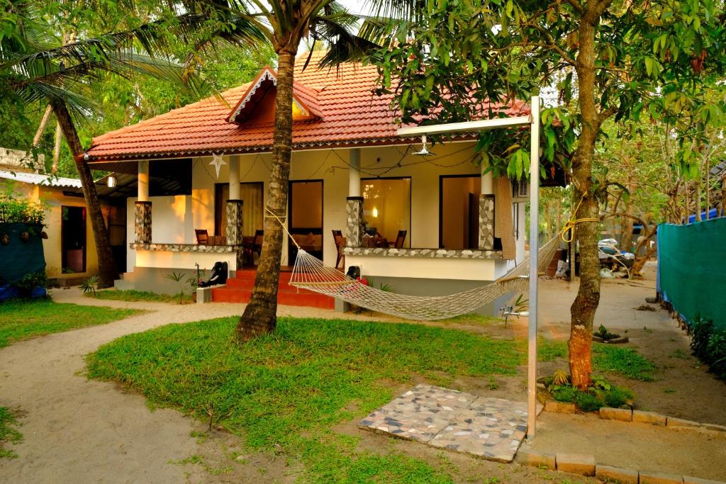 una casa con un'amaca di fronte di Marari Lotus Beach Villa a Mararikulam