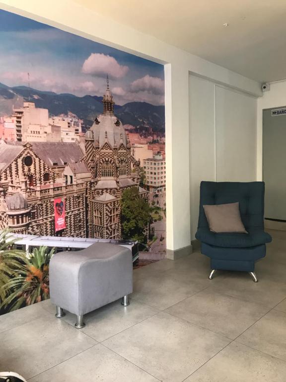 ein Wohnzimmer mit einem Wandbild einer Stadt in der Unterkunft Hotel Alcazar in Medellín
