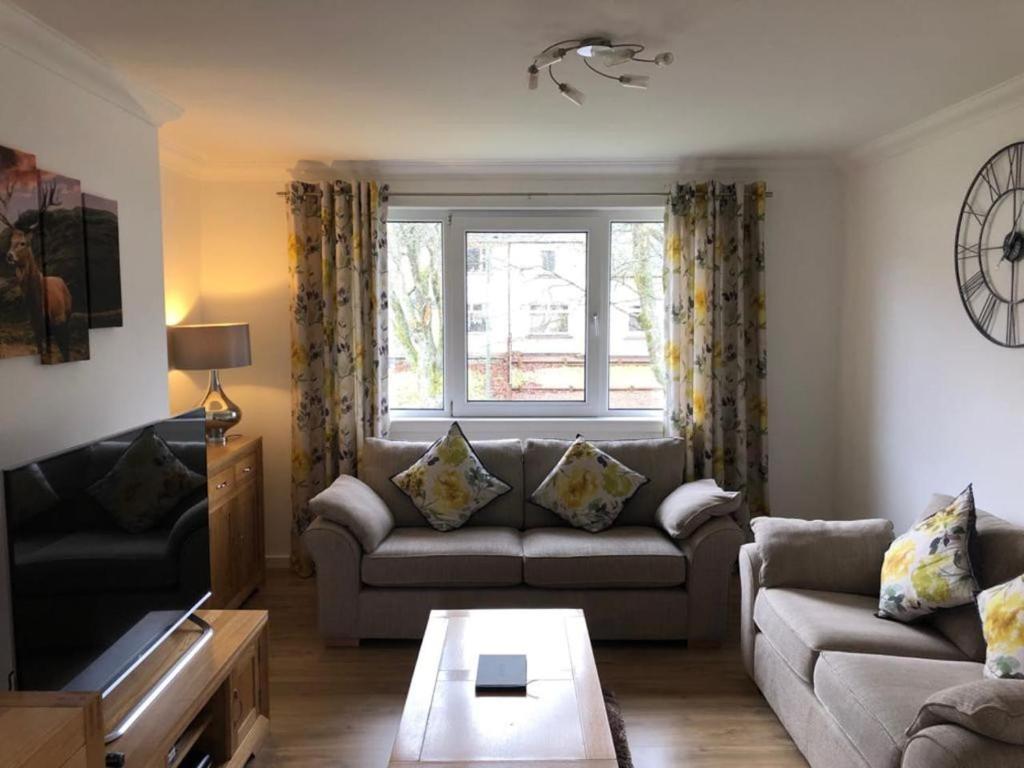 Una sala de estar con un sofá y una ventana. en 12 Lochiel Road, en Fort William