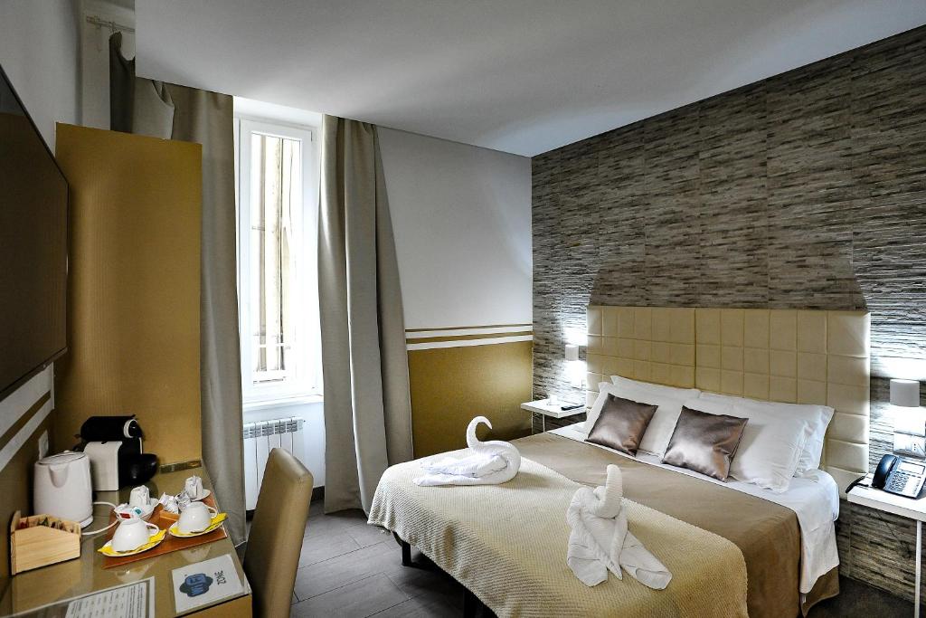 a hotel room with a bed with towels on it at Domus Castroni Pompeo Magno in Rome