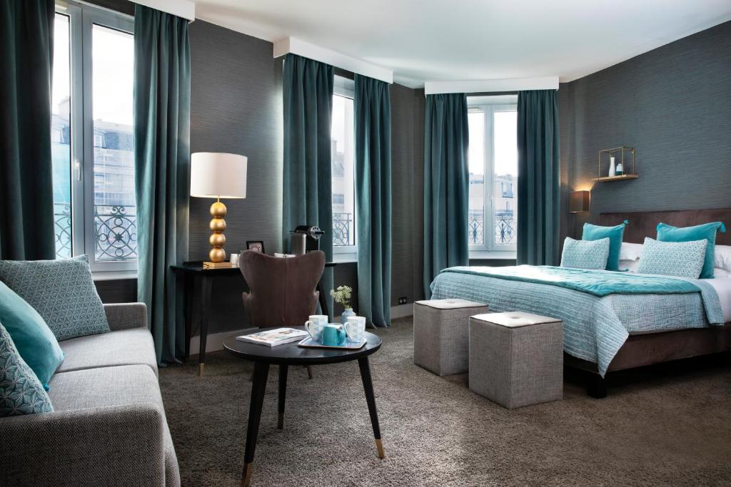 a hotel room with a bed and a couch at Hôtel Plaza Étoile in Paris