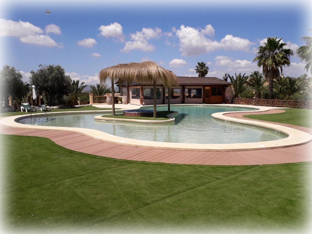 a swimming pool with a gazebo and a house at Agroturismo Es Gallicant in Campos