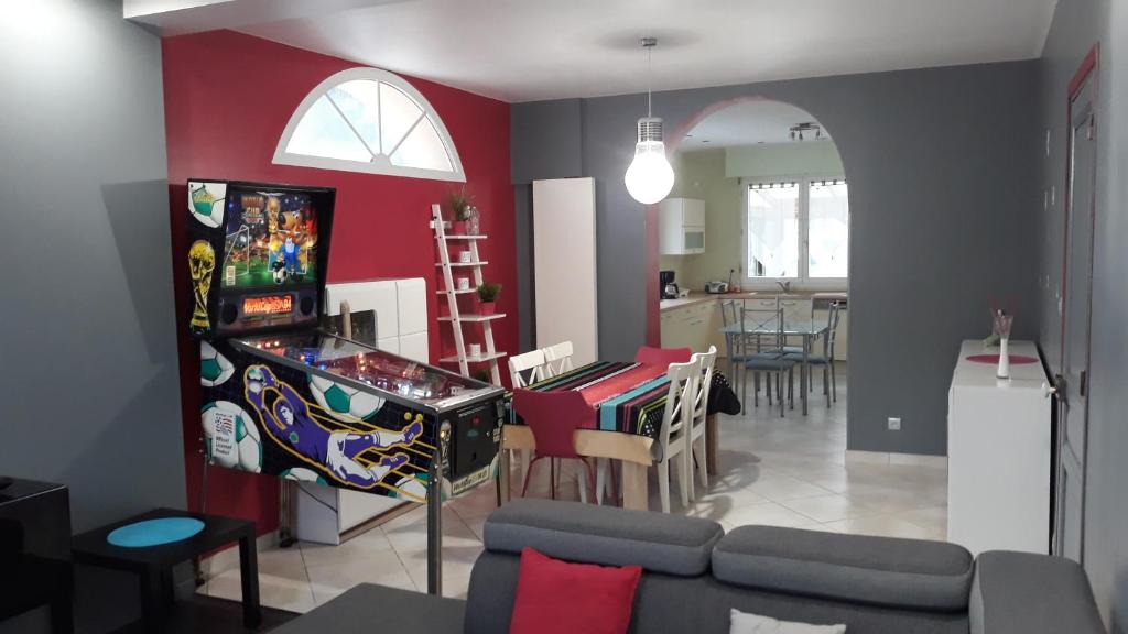 a living room with a video game and a game table at Le Gîte du Magnolia in Willerval