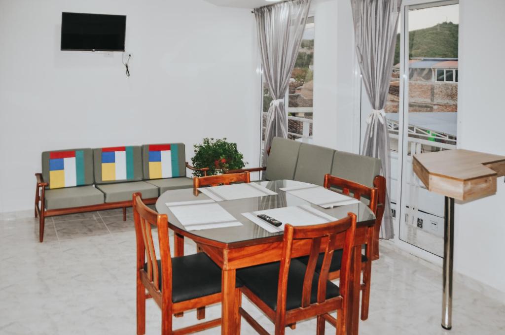 a dining room with a table and chairs and a couch at Bello Apt Buga con Bella vista y refrescante Brisa in Buga