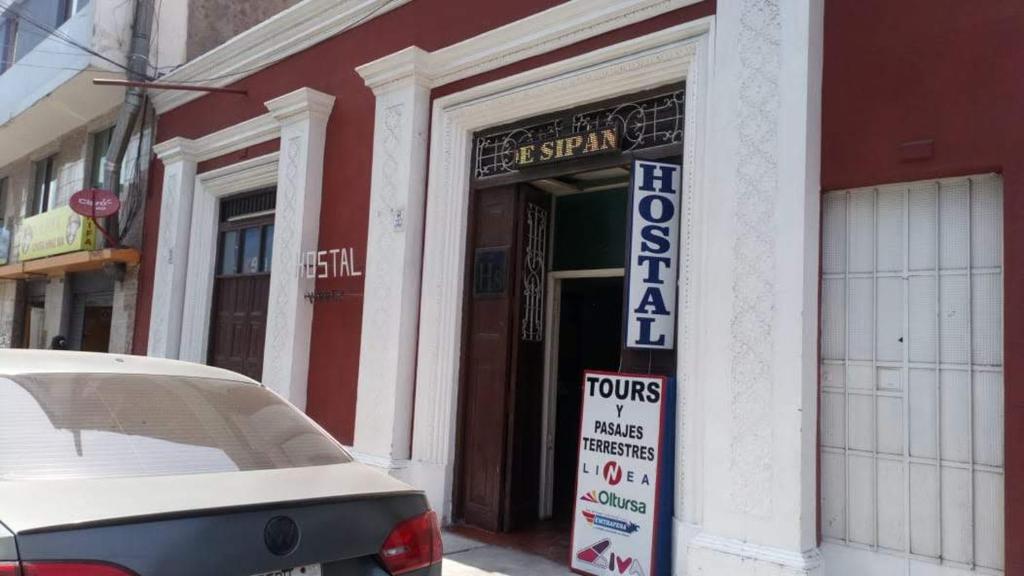 un devant de magasin avec un panneau devant un bâtiment dans l'établissement Hostal Virrey & Tours, à Trujillo