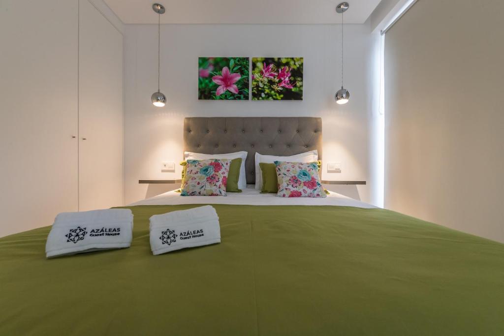 Azaleas Guest House في Ribeira Chã: غرفة نوم بسرير اخضر كبير وبها وسادتين
