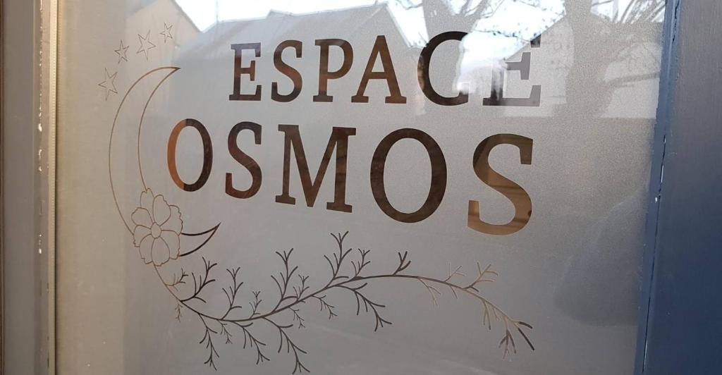 ein Schild in einem Fenster, auf dem Osnos stehen in der Unterkunft Espace Cosmos in Vaux-sur-Sûre