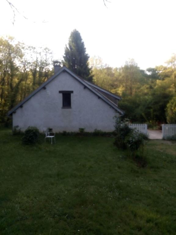 une maison blanche avec une fenêtre dans une cour dans l'établissement La Feuchelle, à Villiers-Louis