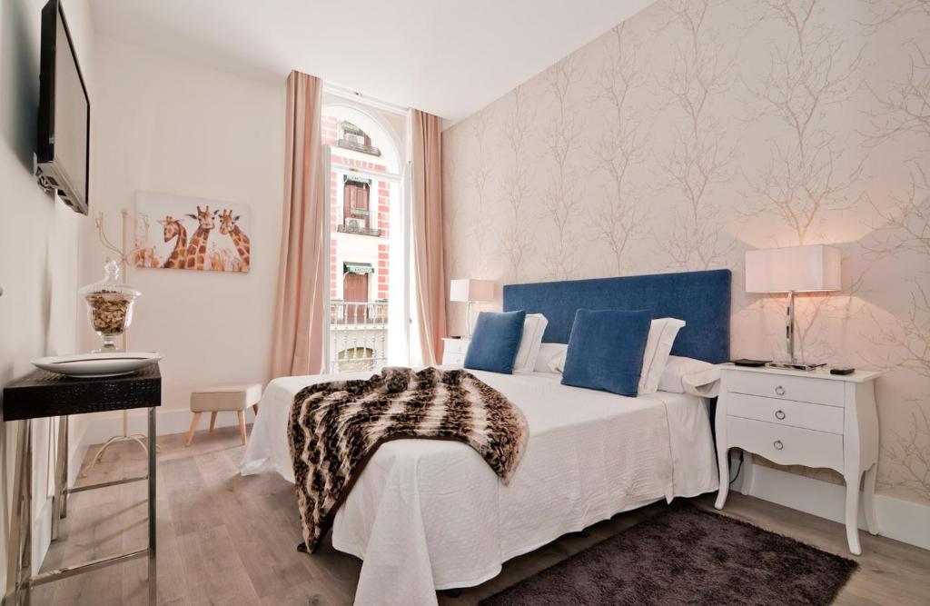 a hotel room with a bed, table, and window at Behap Madrid Puerta del Sol in Madrid