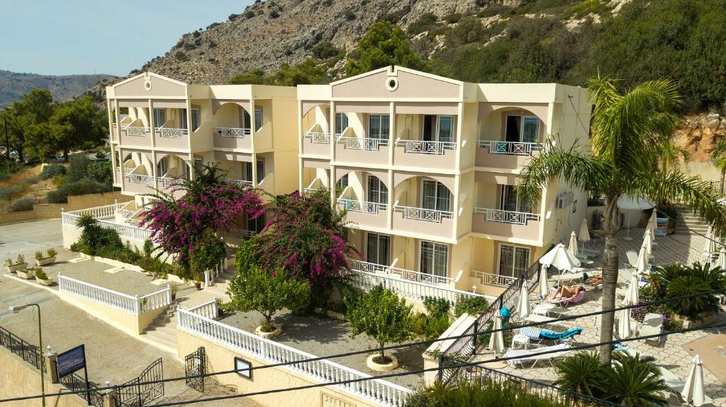 a large yellow building with a mountain in the background at Stella View Studios in Pefki Rhodes