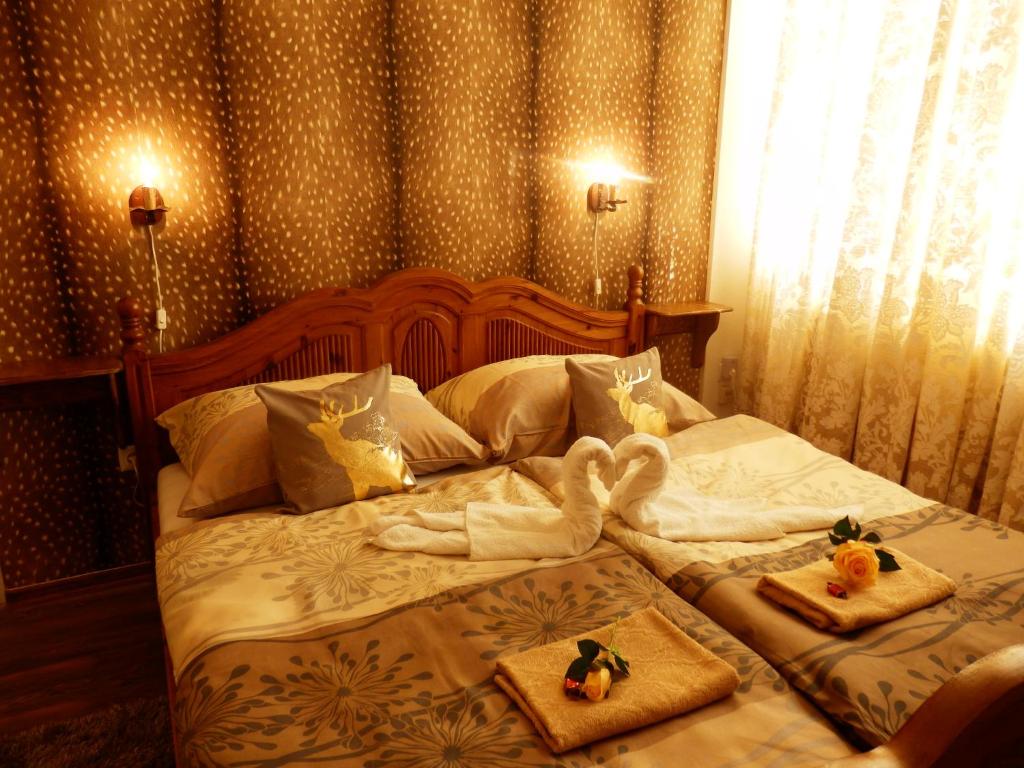 Una cama con dos toallas y dos muñecas. en Guesthouse Ilona, en Veľký Kamenec