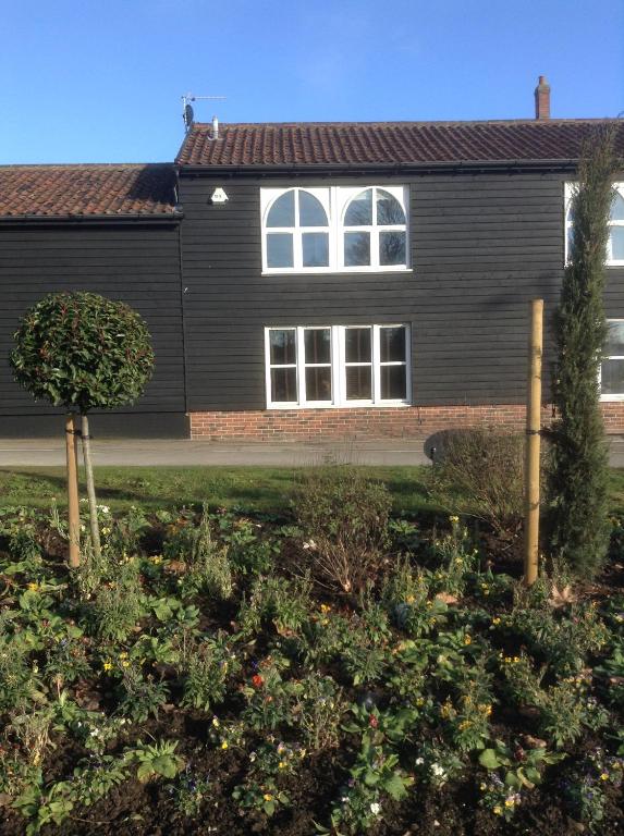 una casa con un jardín delante de ella en Little Bury Barn en Bury Saint Edmunds