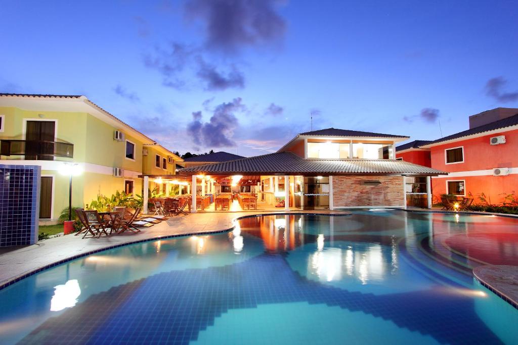 a swimming pool in front of a house at Aquaville Apart Hotel in Porto Seguro