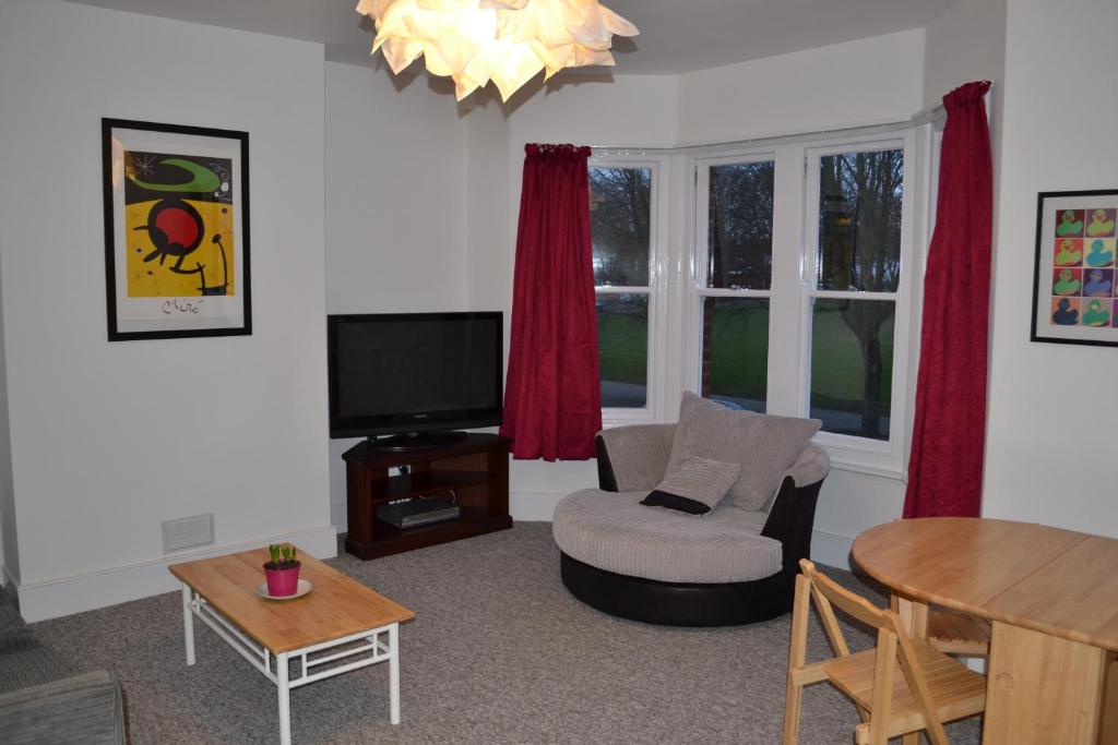 a living room with a tv and a table at Park View - Two bedroom apartment in Worthing