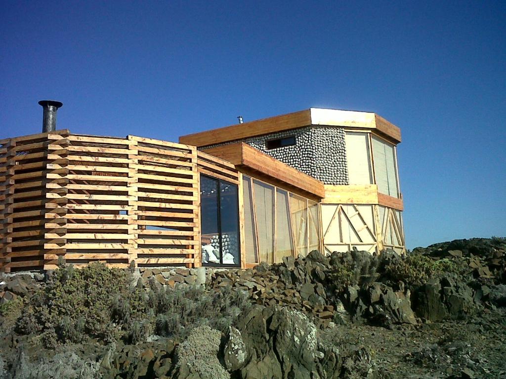 a house on top of a hill with rocks at Loco´s Home in Chañaral de Aceituna