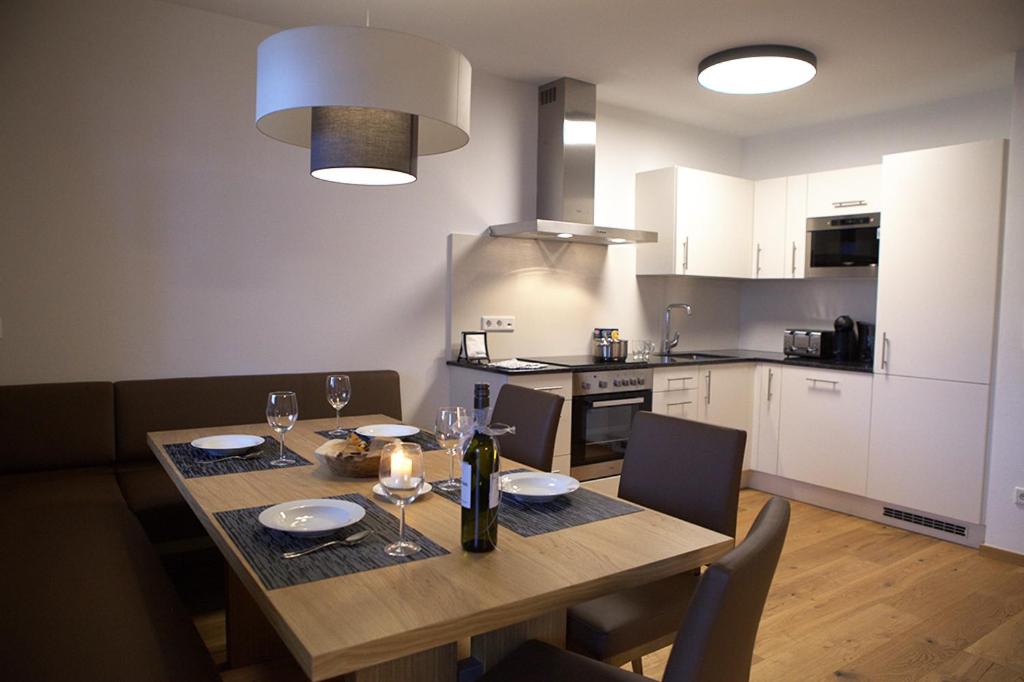 a kitchen with a wooden table with wine glasses on it at Kitzbuheler Alpen Residenz Top2 Hollersbach in Hollersbach im Pinzgau