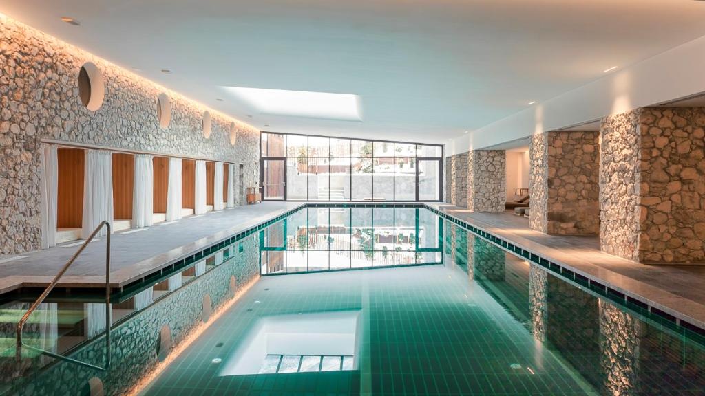 - une piscine dans un bâtiment avec piscine dans l'établissement Faloria Mountain Spa Resort, à Cortina dʼAmpezzo