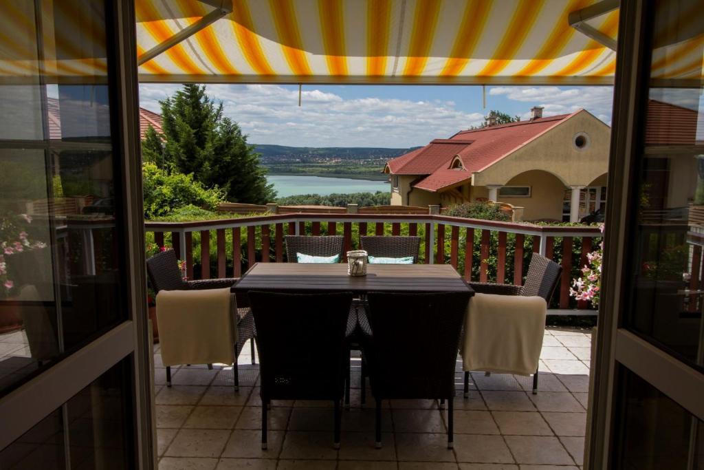 un tavolo su un balcone con vista sull'acqua di Holiday home in Balatonfűzfo 35646 a Balatonfůzfő