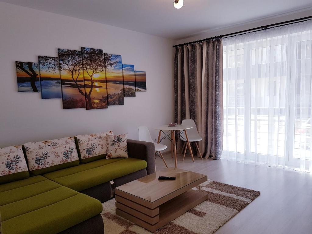 a living room with a green couch and a table at Dream Apartment Brasov - West in Braşov