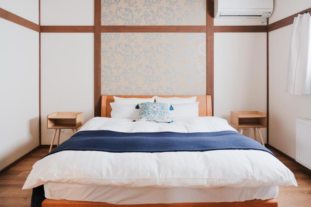 sypialnia z dużym łóżkiem z niebiesko-białym kocem w obiekcie Lampstand STAY Sapporo w mieście Sapporo