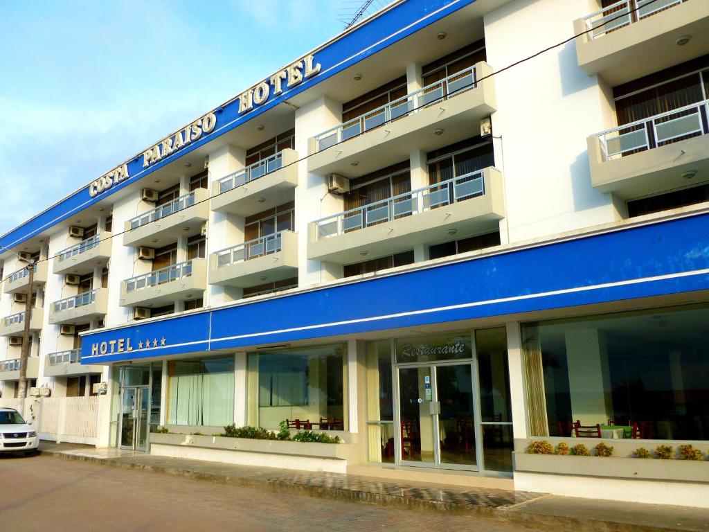 a hotel with a blue sign on the side of it at Costa Paraiso in Atacames